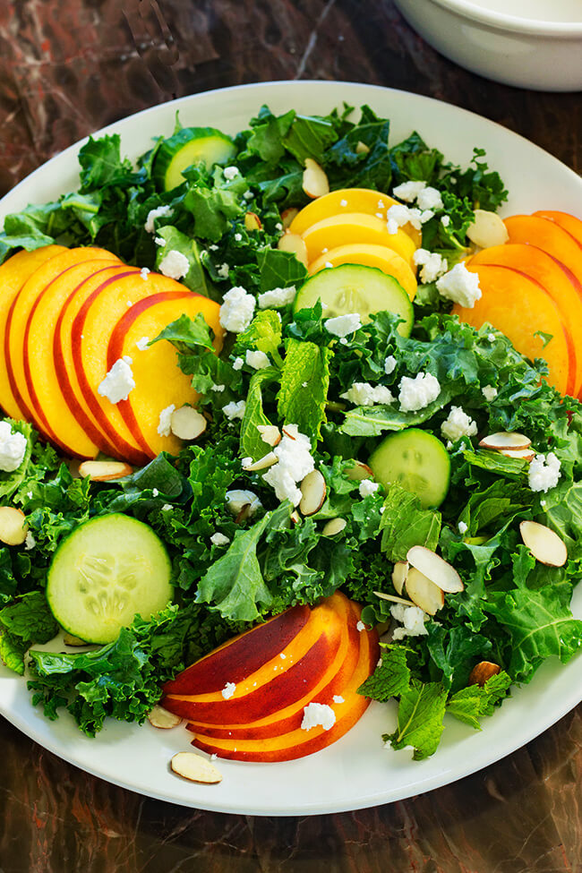 This peach goat cheese kale salad showcases ripe peaches, tangy goat cheese and crunchy almonds with a delicious balsamic vinegar dressing. 