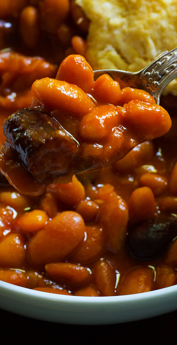 Just five basic ingredients: sausages, navy beans, molasses, sriracha and mustard tossed in a slow cooker. Best baked beans, make them today!