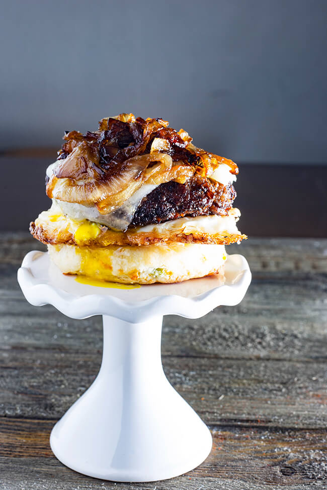 This Cheddar Steak Egg & Cheese Biscuit Sandwich is the perfect breakfast sandwich to start your day or the perfect breakfast for dinner option. A mouthwatering country-fried steak on a freshly baked, scratch-made biscuit topped with a crispy fried runny egg and spicy carmelized onion. This is it!